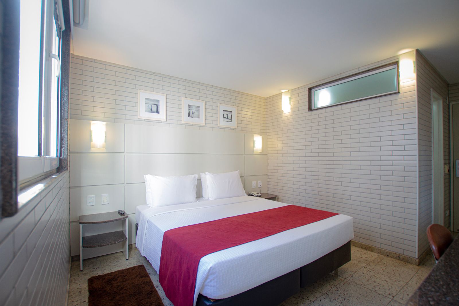 Standard Casal com cabeceira estofada, iluminação lateral e piso claro — Hotel Confiance Batel