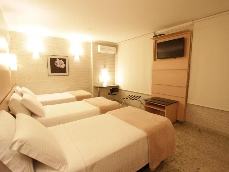 Apartamento Standard Quádruplo Twin com quatro camas de solteiro, TV e escrivaninha — Hotel Confiance Centro Cívico